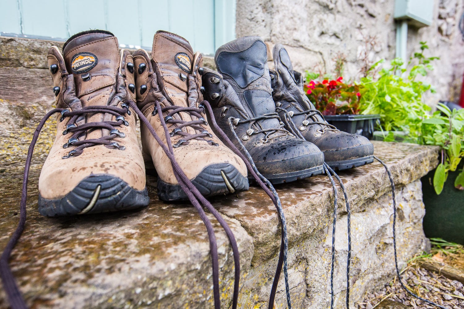 Two pairs on walking boots on a porch
