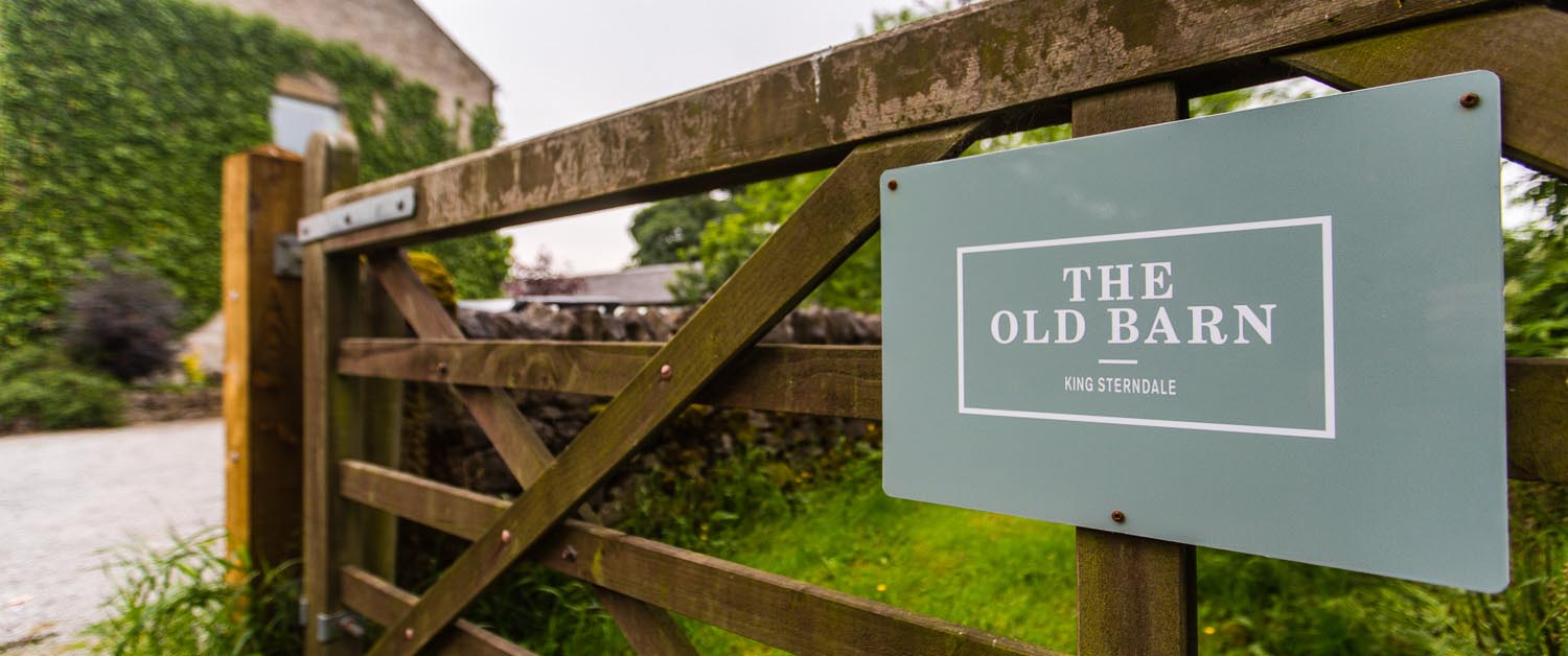 The gate of The Old Barn with a sign